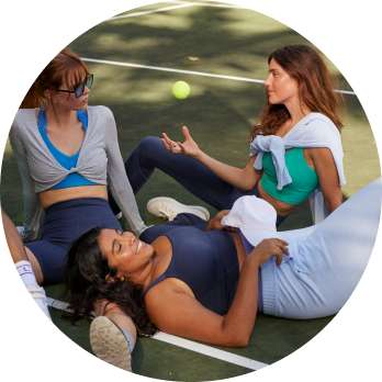 models in aerie offline outfits sitting on tennis court