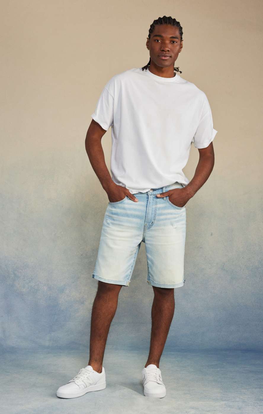 Model in light wash denim shorts and white tee shirt