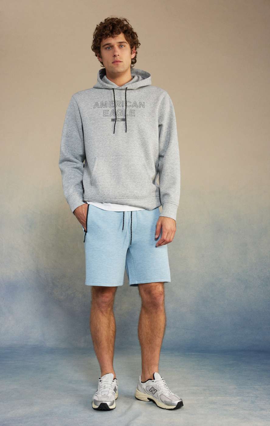 model in blue jogger shorts and grey hoodie