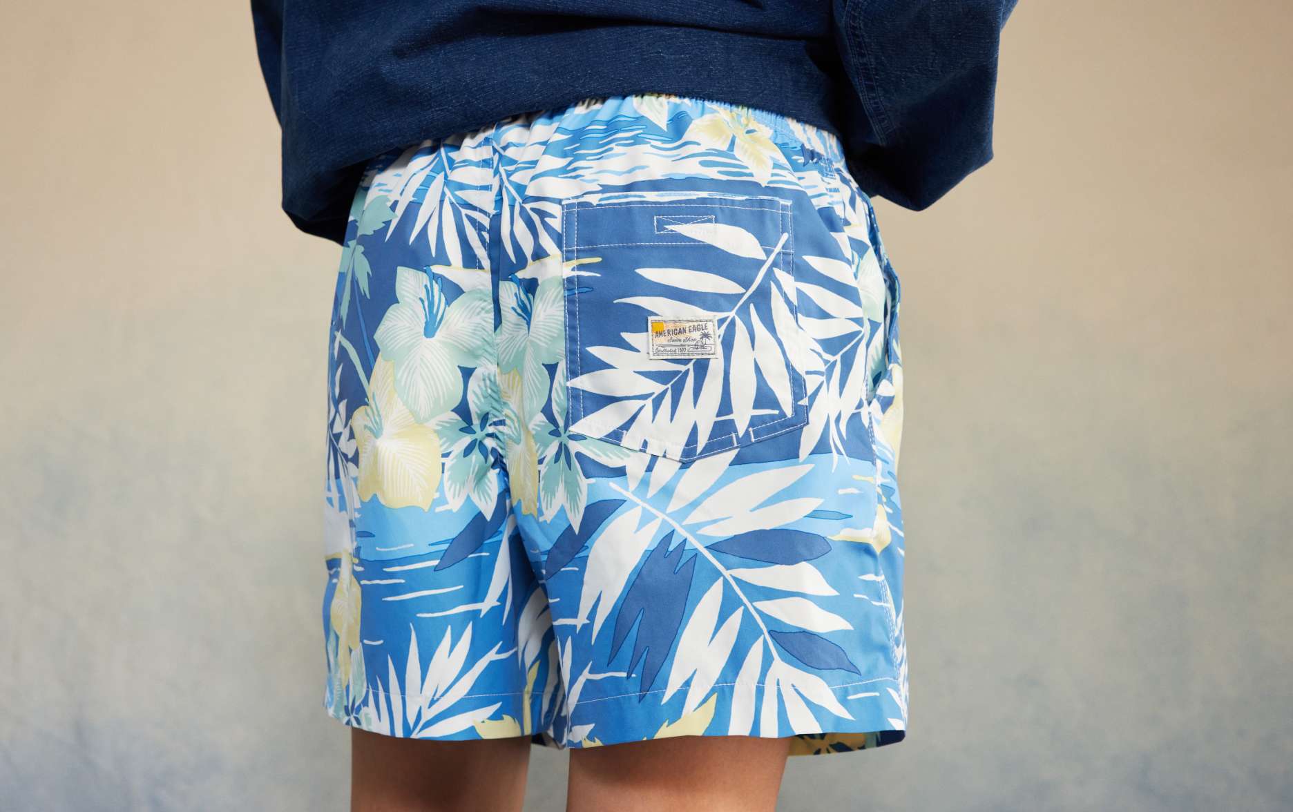 model in blue palm printed swim shorts