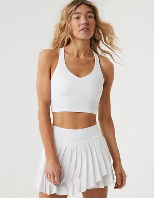 white sports bra with white tennis skirt and grey sweater