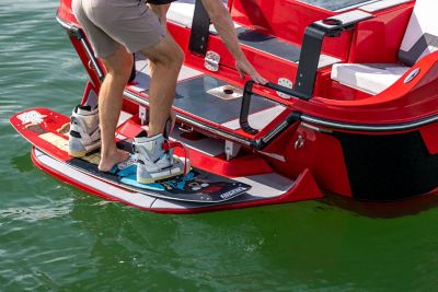  wakeboarder gets ready on the back of a red H20 wake boat