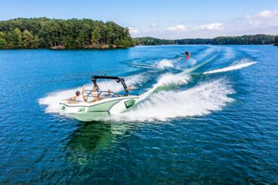 green Heyday boat towing a wakeboarder