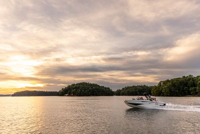  White H22 wake boat running at sunset