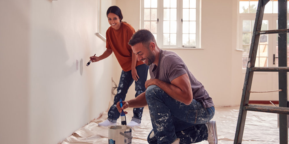 Couple Painting Walls Together At Home