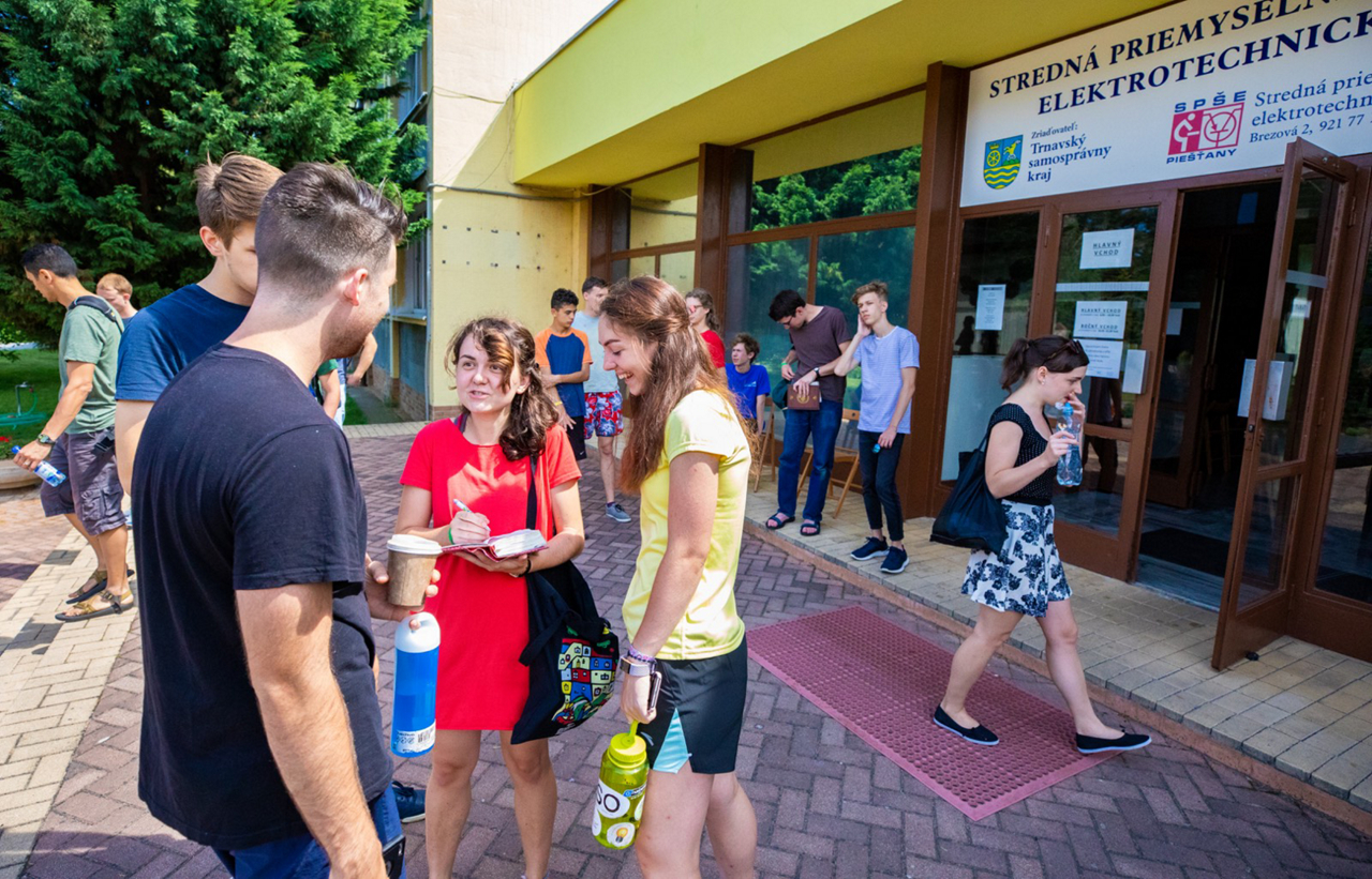 camp volunteers speak with students outside