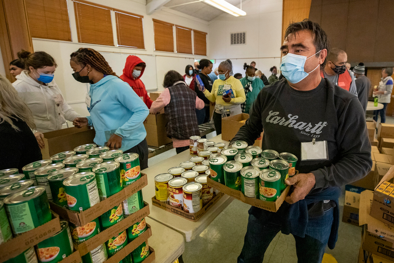 A church volunteer restocks fruit cocktail to keep the Boxes of Love® assembly line in motion.