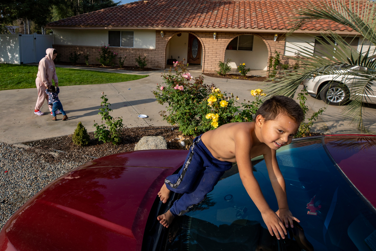 While Jose and Rossana care for his mother inside her house, their oldest daughter, Estefany (in pink), plays with her little sister and cousin.