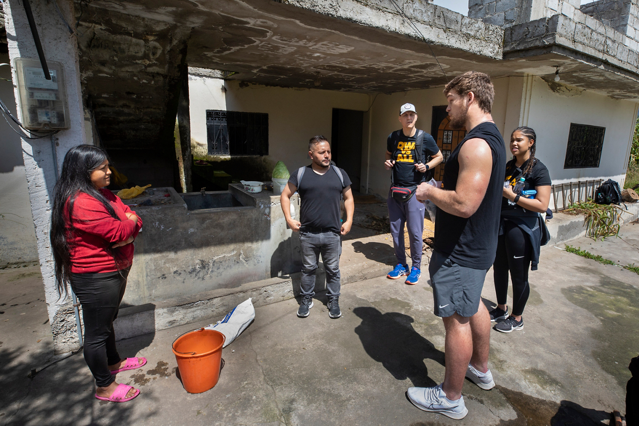 Berenice Tituana (left) listens to Logan explain how the water filter works.