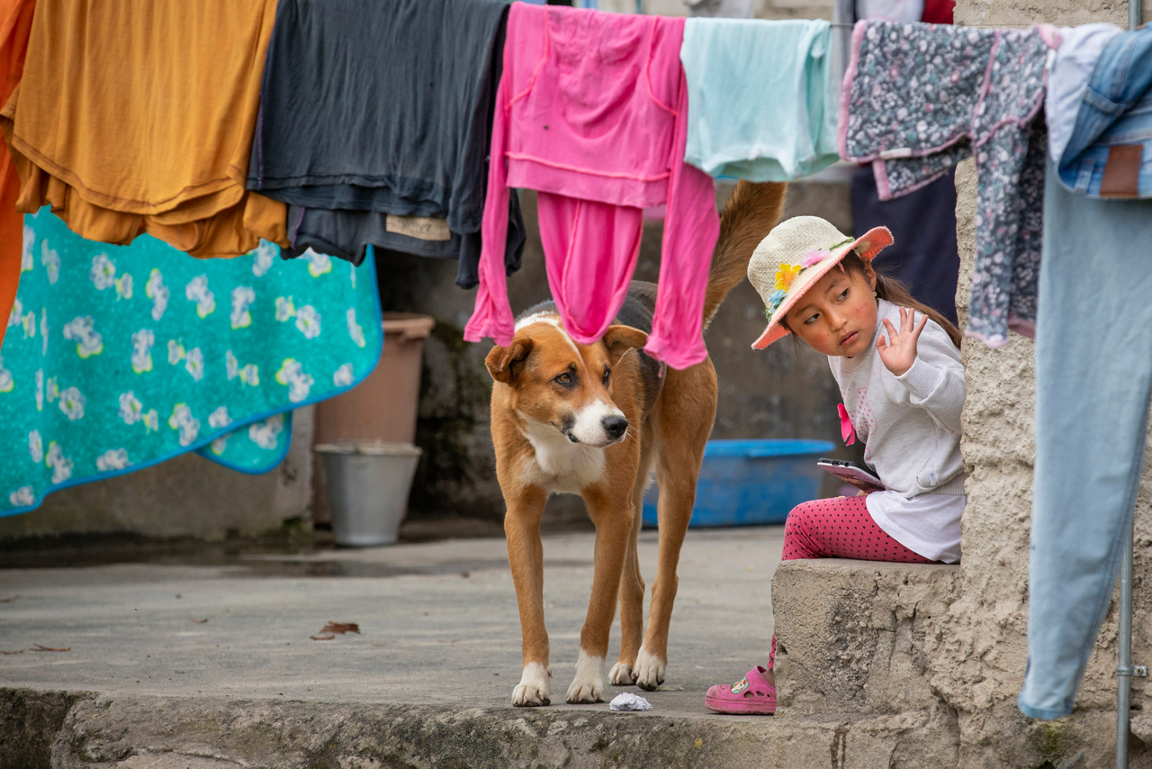 A young girl watches the Athletes in Action® group pass by her home.