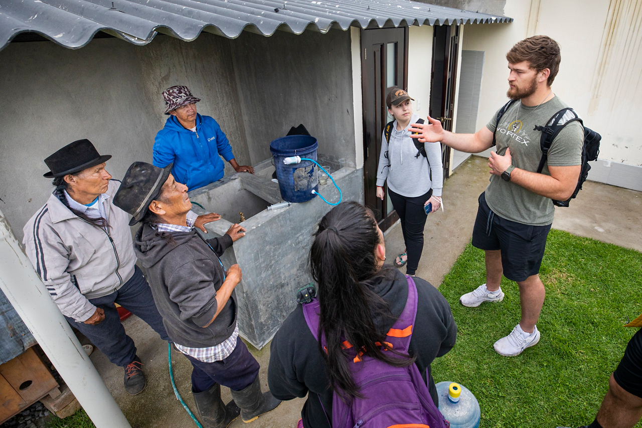 Logan (far right) talks about the good news of the gospel with Jose (left, in dark jacket) and other men.