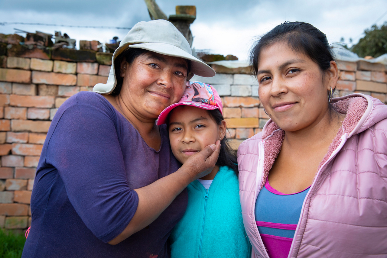 Maximo Luzon (left) and her daughters receive a water filter from the Athletes in Action® group.