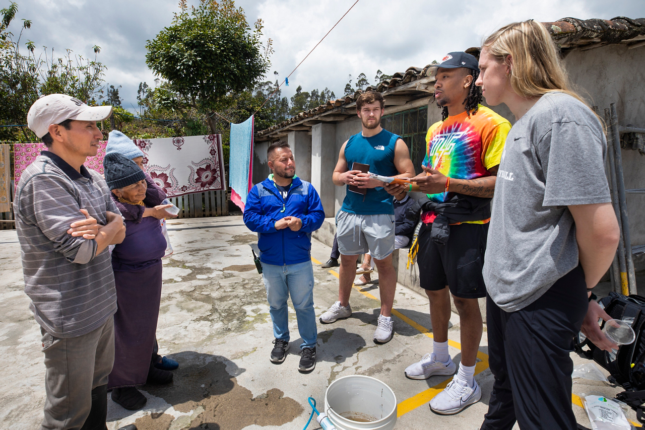 Desmond Hutson, wide receiver, shares the gospel with Luis Vinveza and his family. 