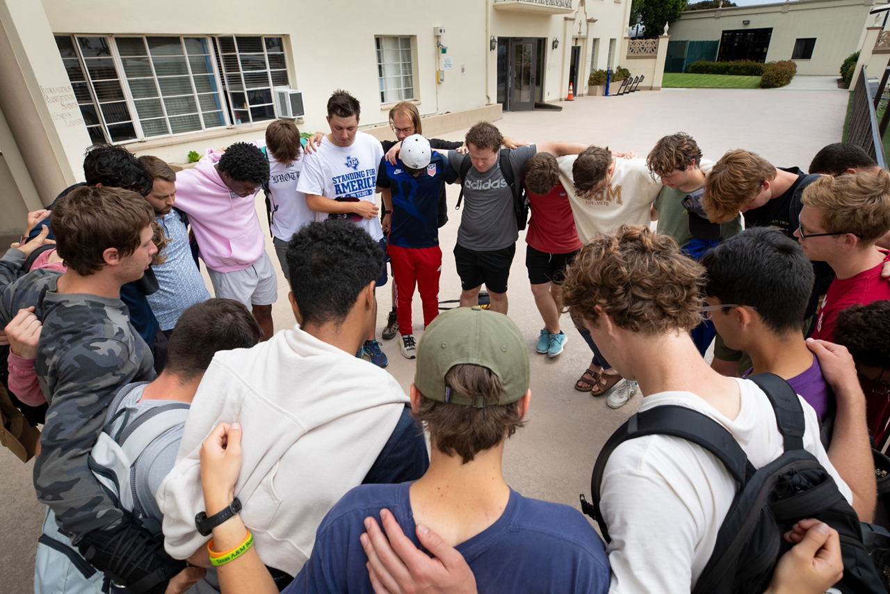 a circle of men praying together