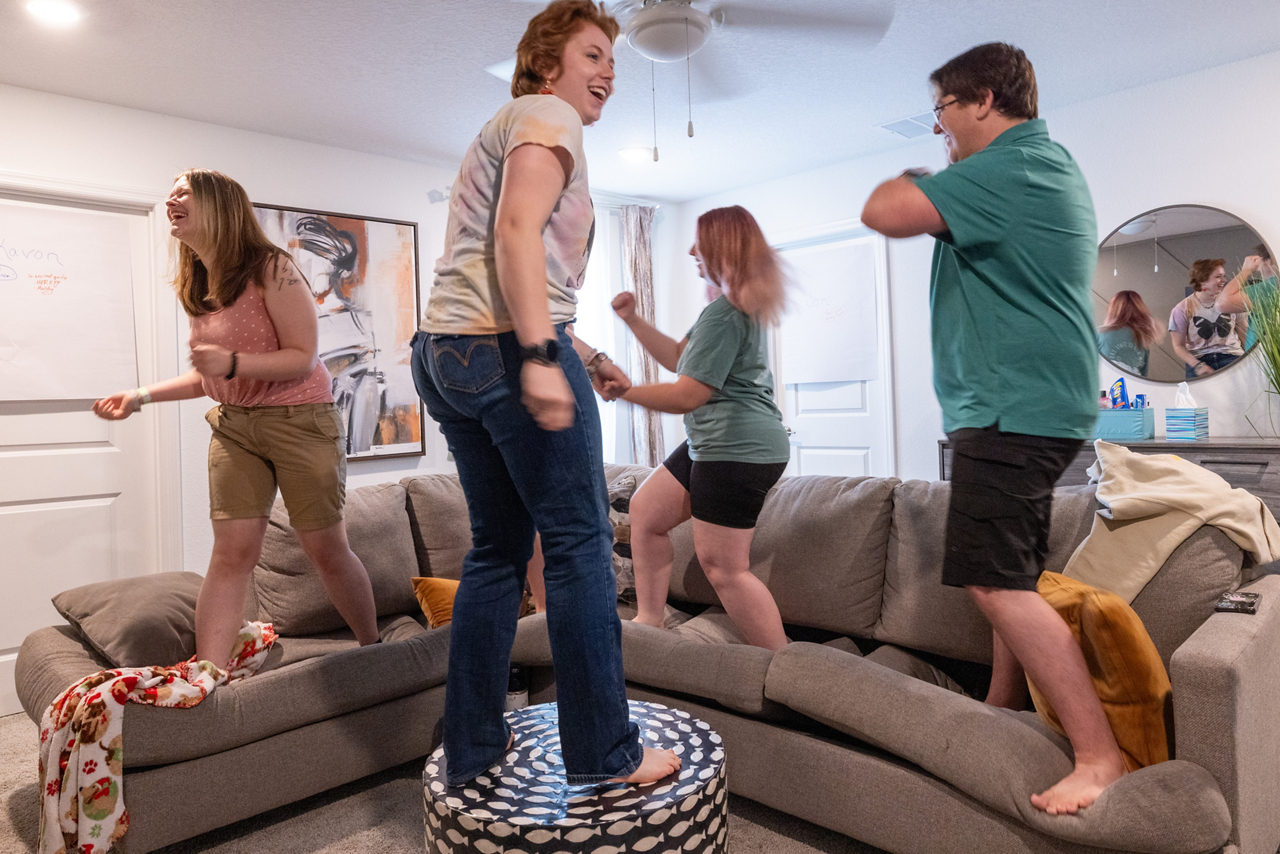 students stand on couch and ottoman