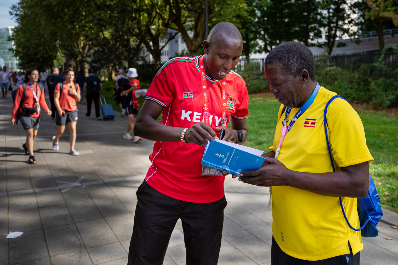 David Cheromei shares an AIA bible with Ugandan Olympic leader