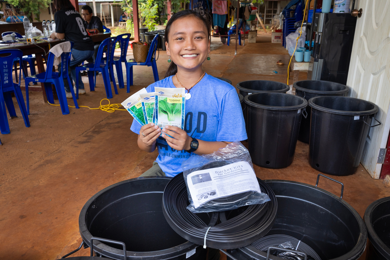 woman volunteer smiling while holding donated items