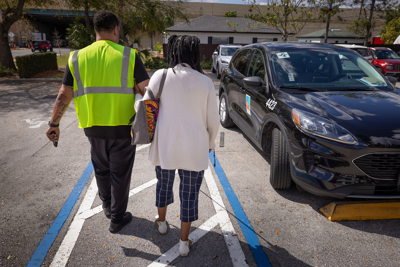 Lorna Johnson, losing sight article. Walking with Access Lynx driver to go home. 