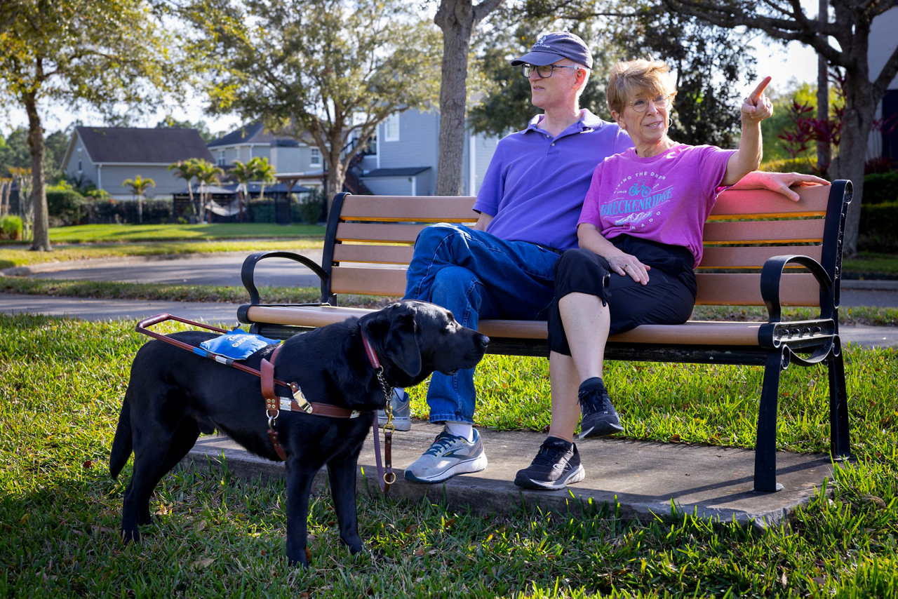 John Powers, blindness article. John and Ann sitting in a park near their home. Notice Ann is pointing at something and John has no idea. 