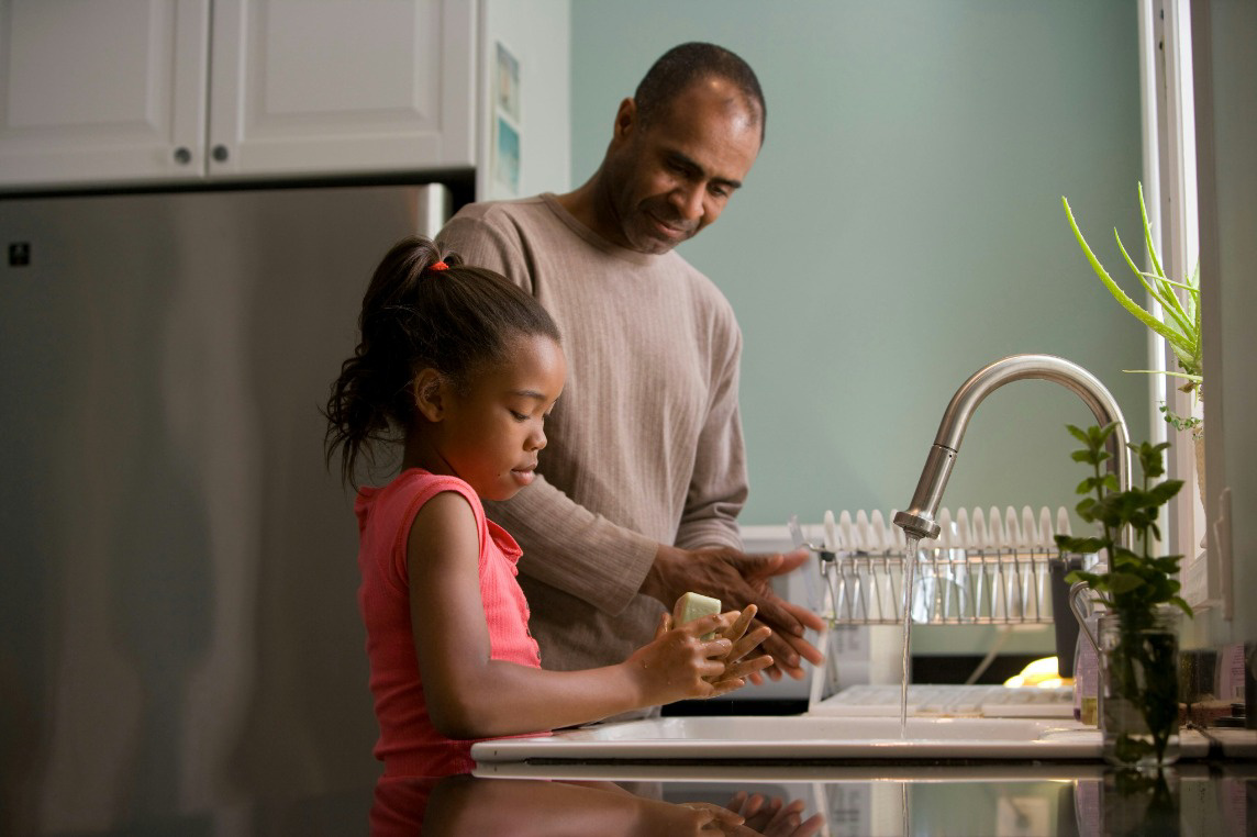 dad and daughter washing hands in kitchen