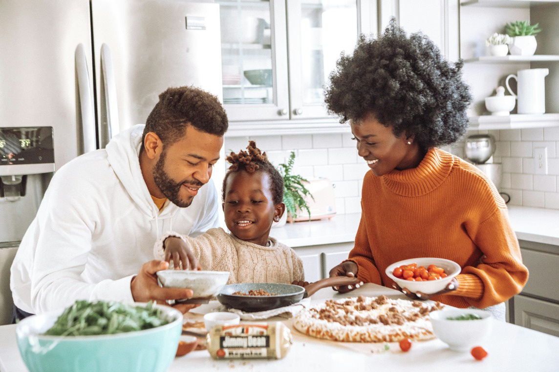 family in kitchen making food and smiling