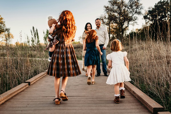 family walking on a path for a photoshoot with kids running to parents