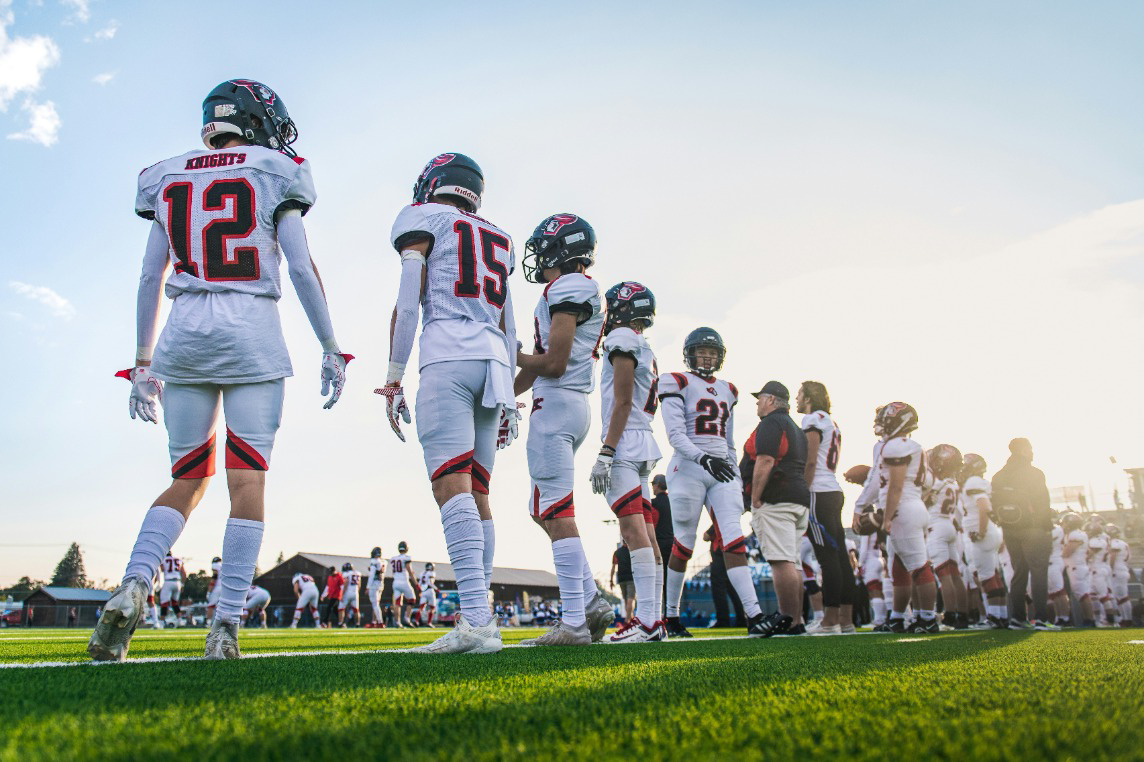 football team watching game from sidelines