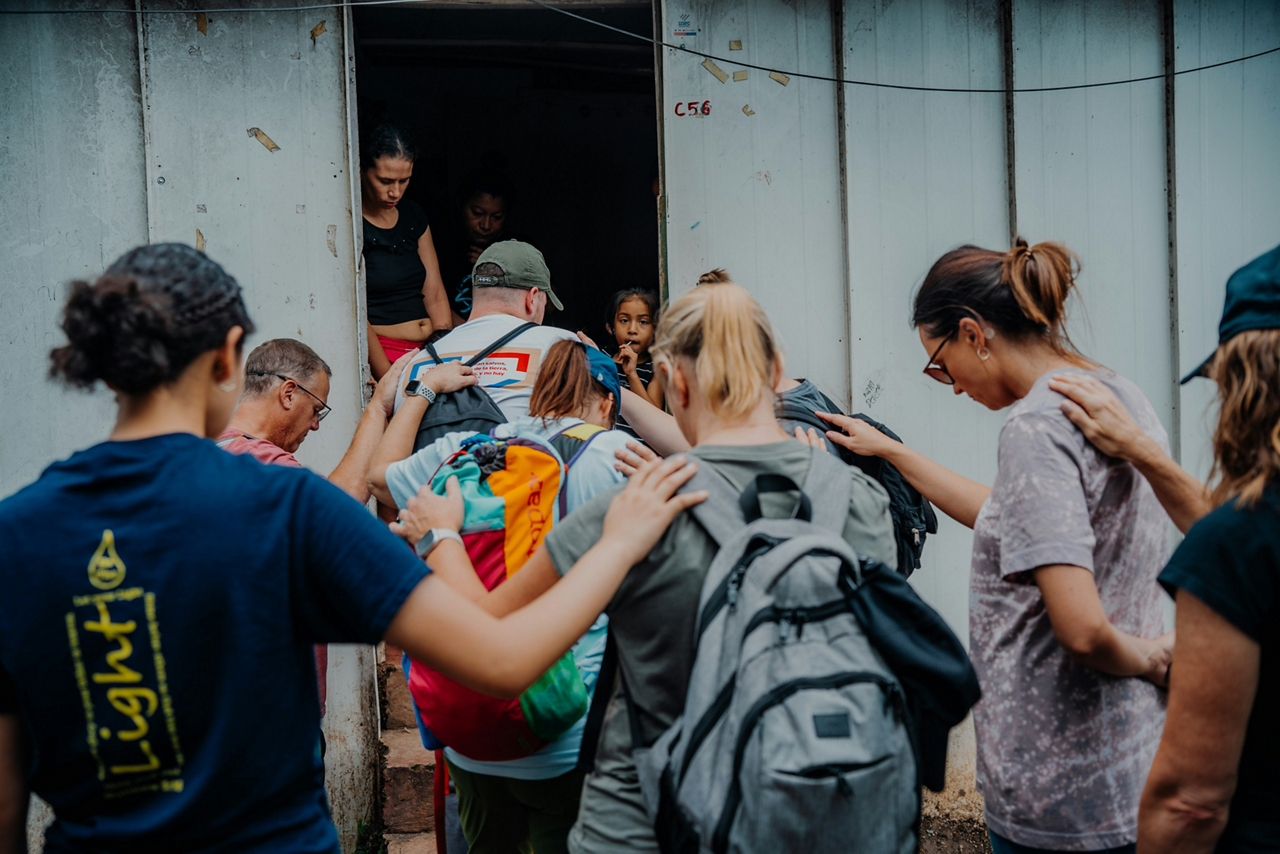Group of people praying over a building