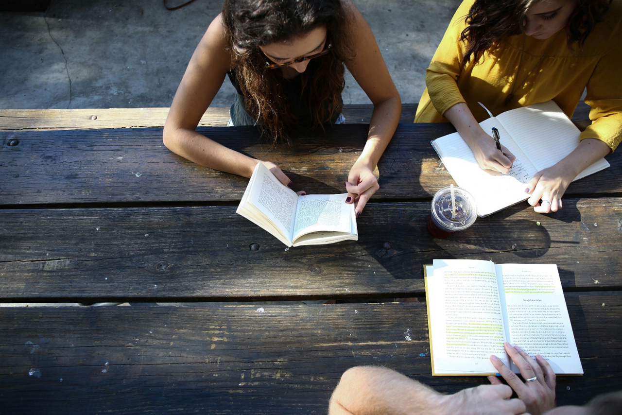 group study session with open notebooks on a table outside