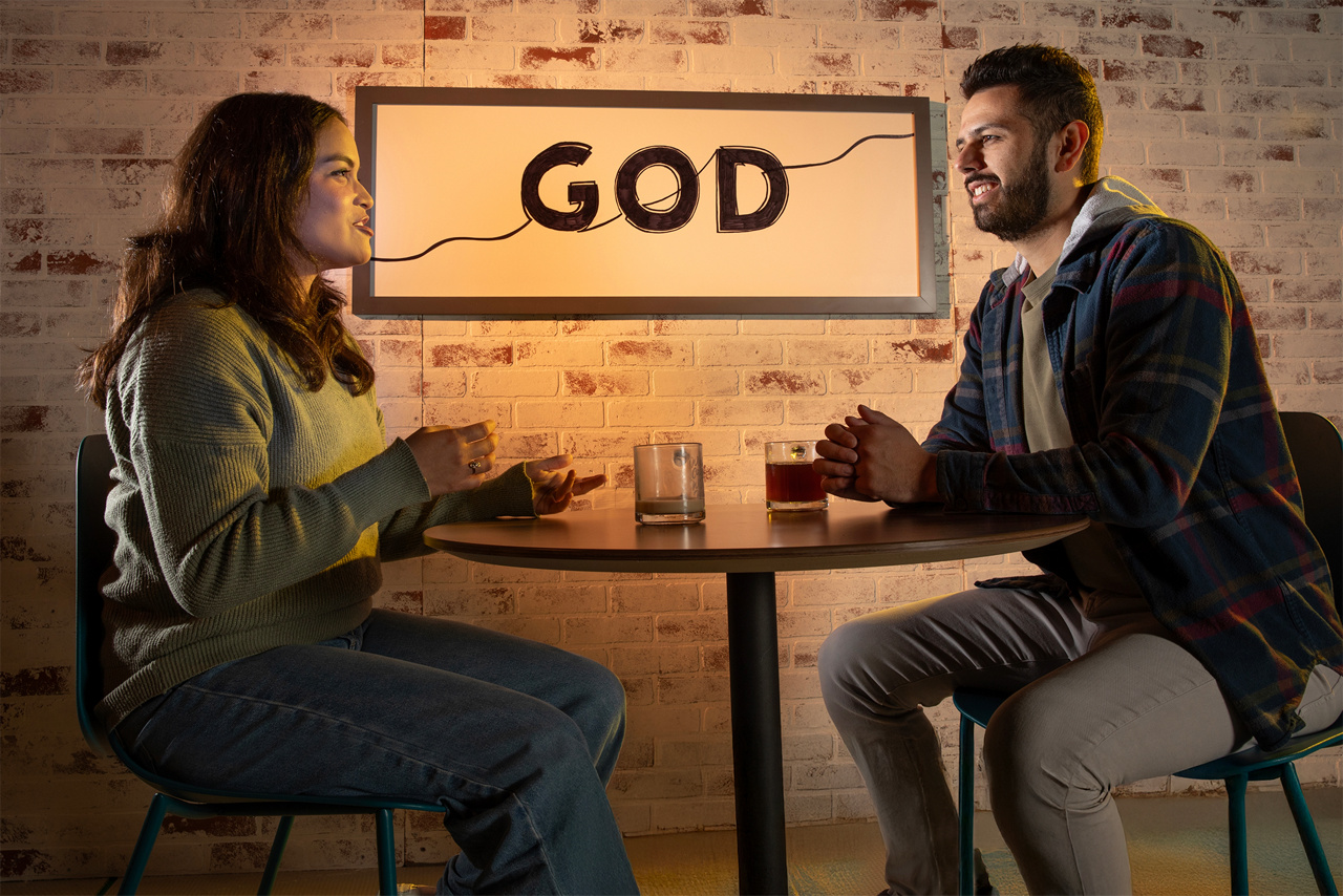 People sitting at coffee shop with signs representing discussions about God.