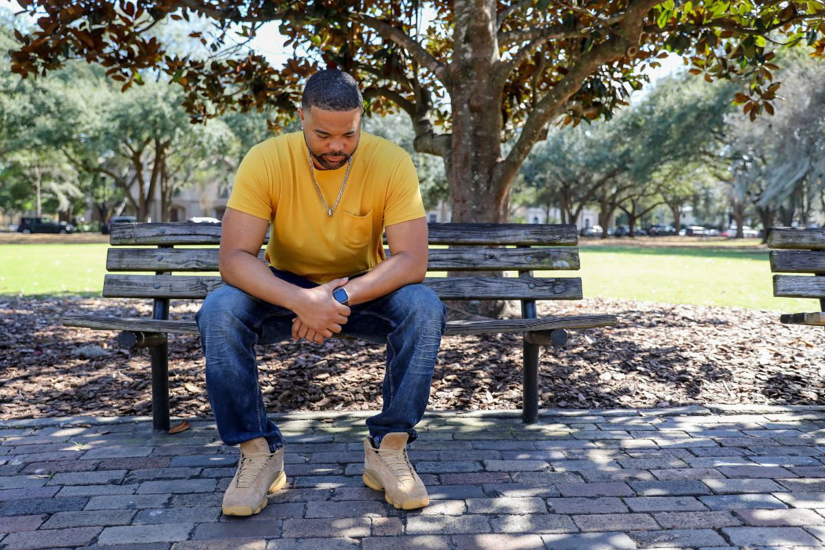 man sitting on bench in city park 01 - 1