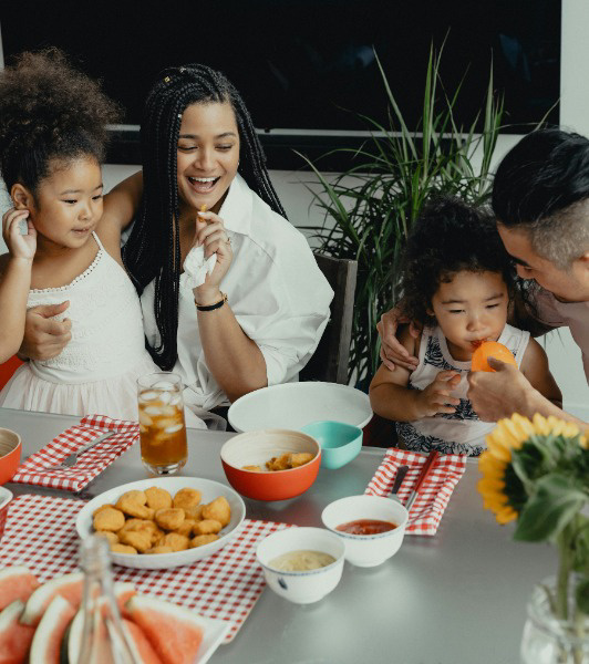 family eating lunch with smiles on their face