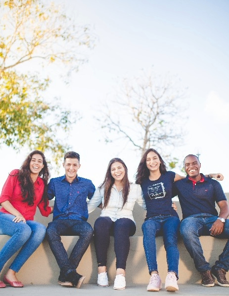 Students sitting on bench posing for a picture.