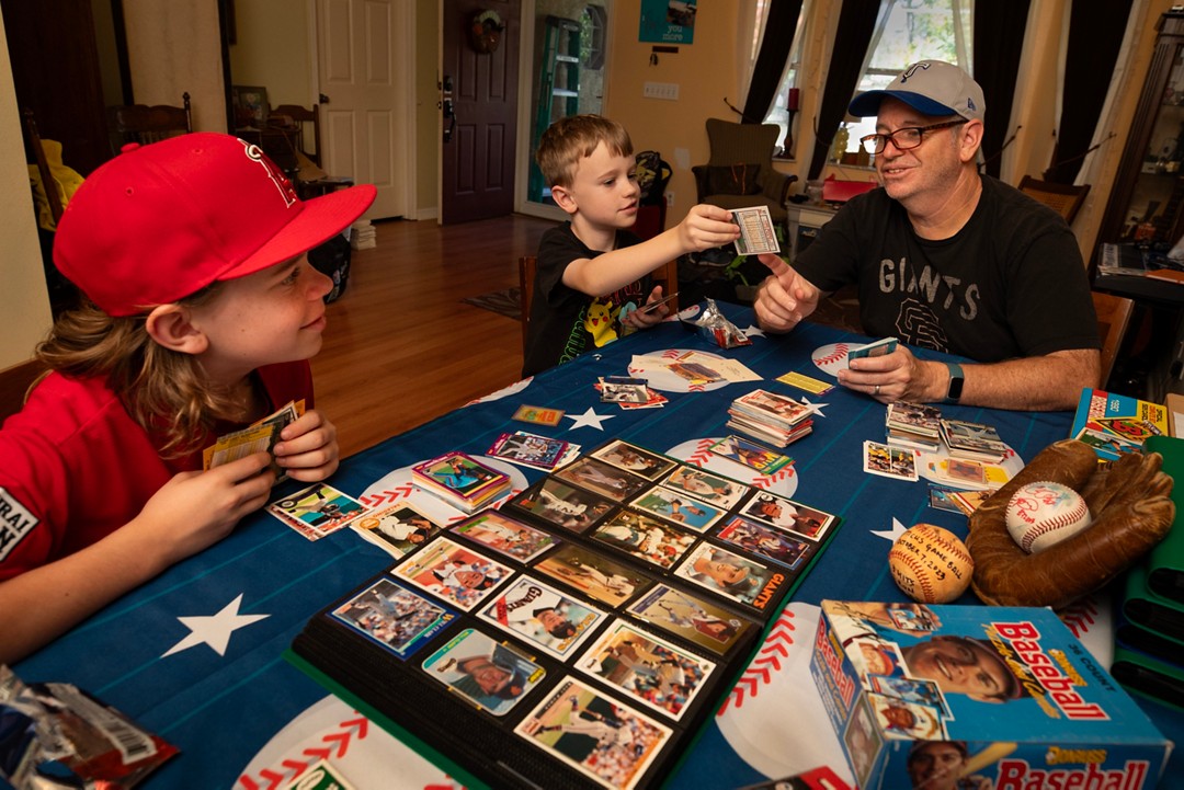 man with baseball cards and kids