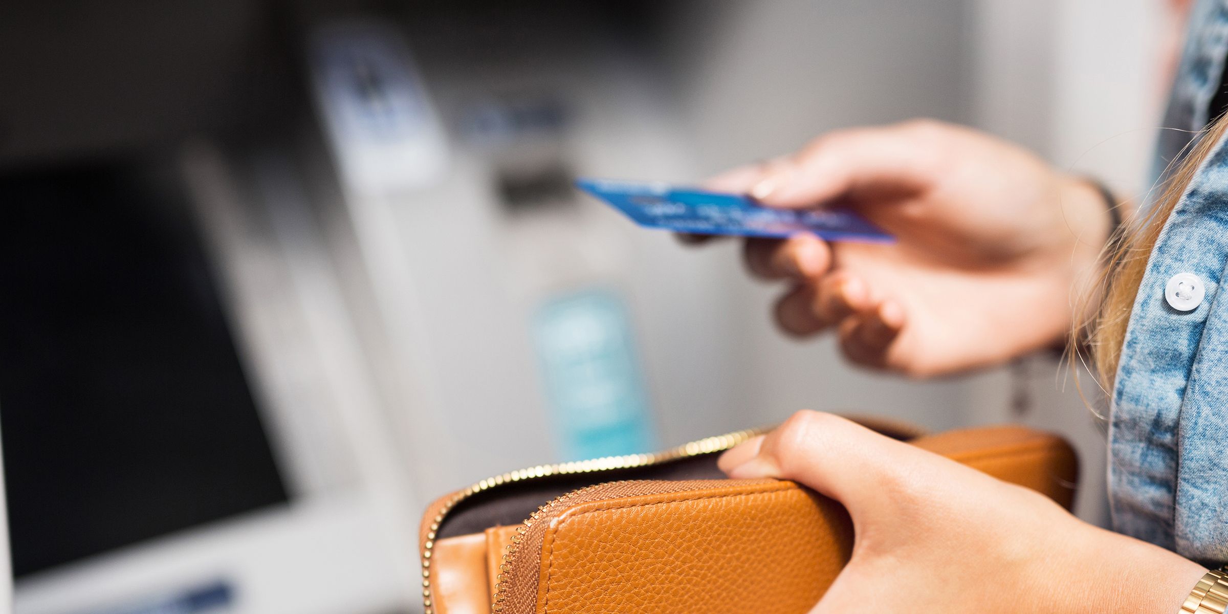 a person holding a purse in one hand and another electronic card