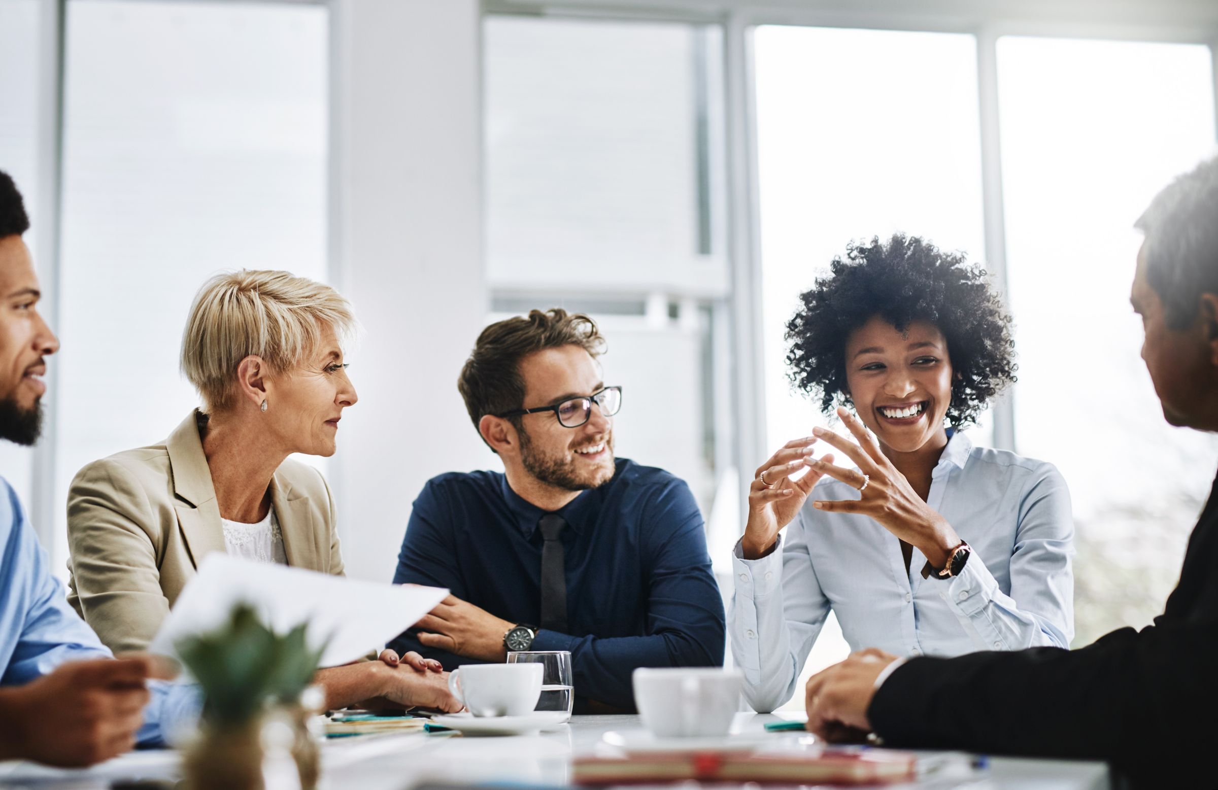 a group of people sitting and discussing around a table