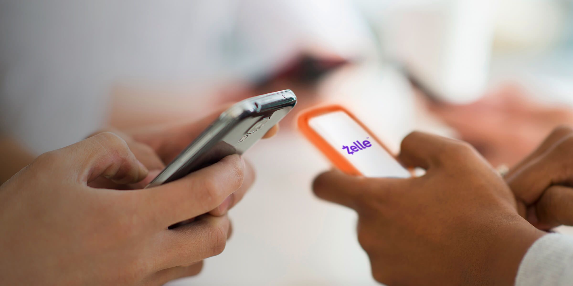 Two people using zelle on mobile phones