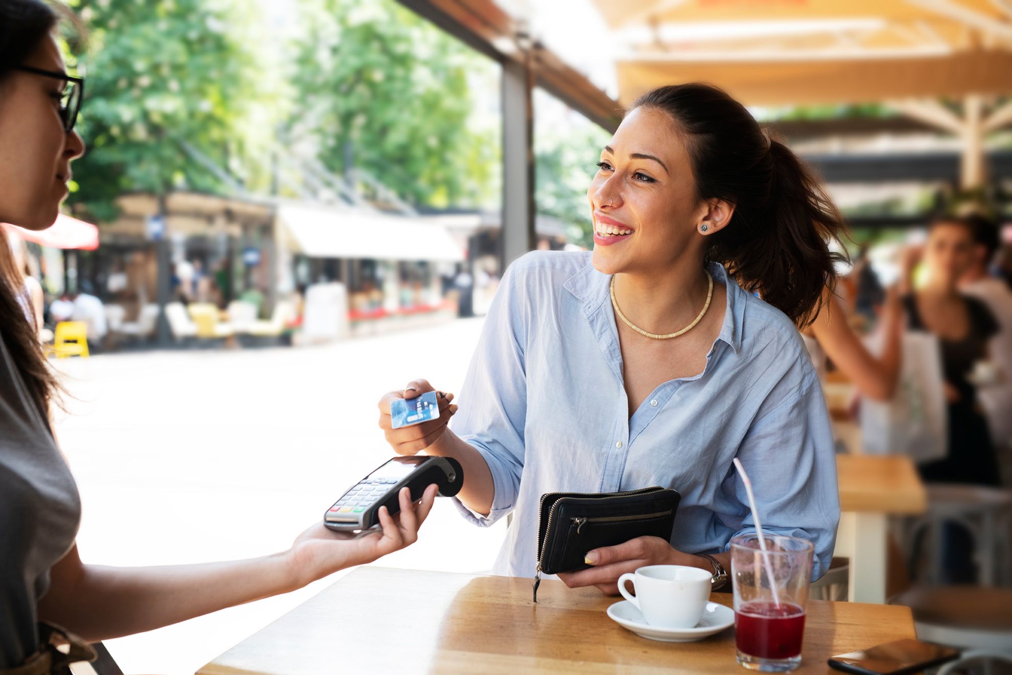 Person paying with a card at a table