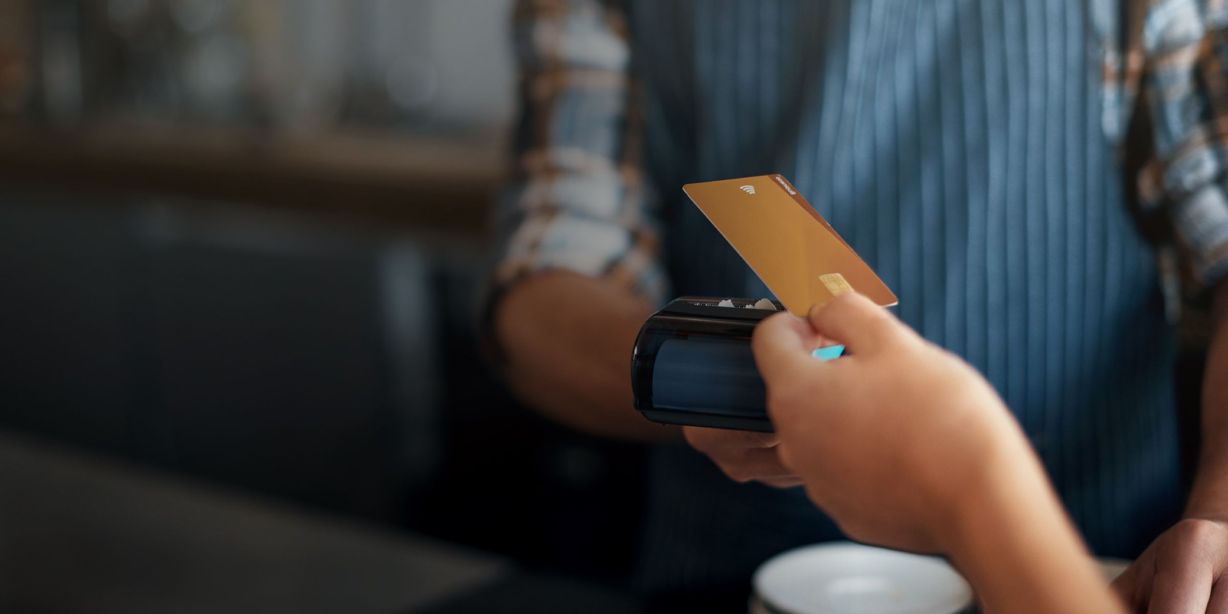 a person is tapping and paying a bill using an electronic card