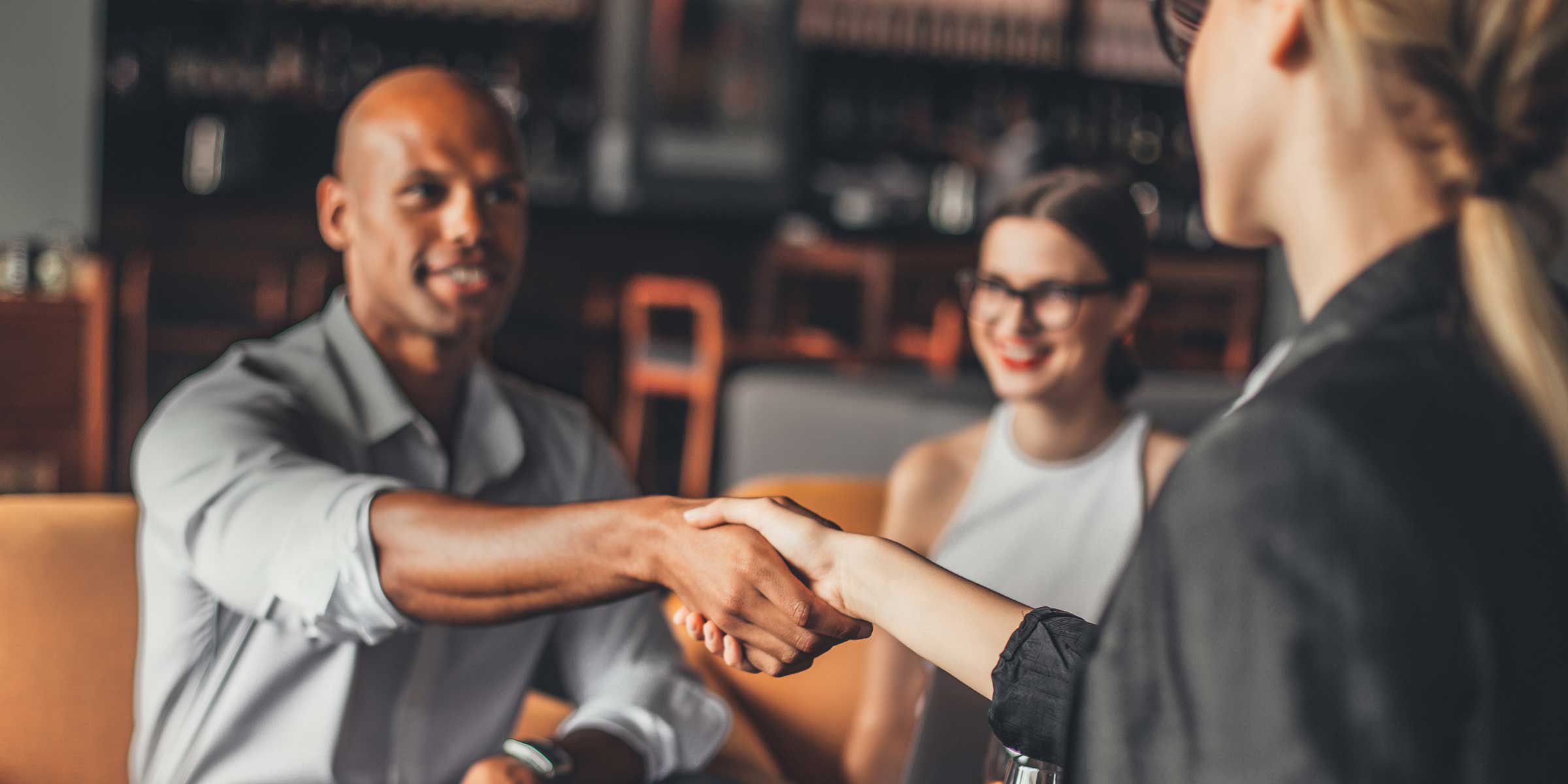 a man shaking hands with a woman