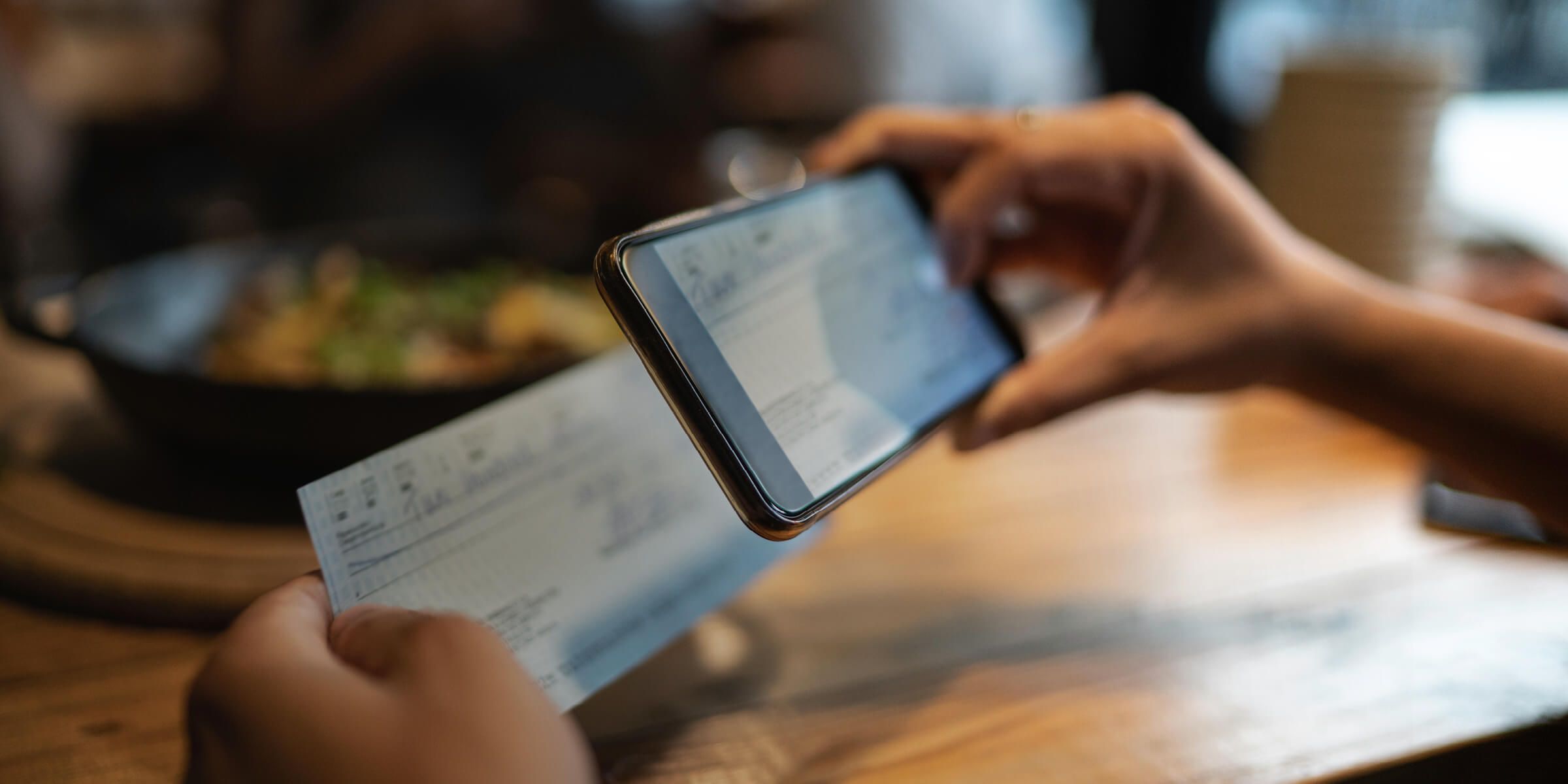 a person taking a photo of a bank cheque