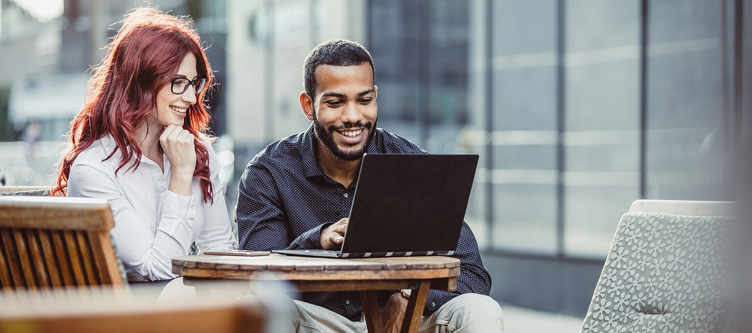 Smiling Man and woman working at laptop computer