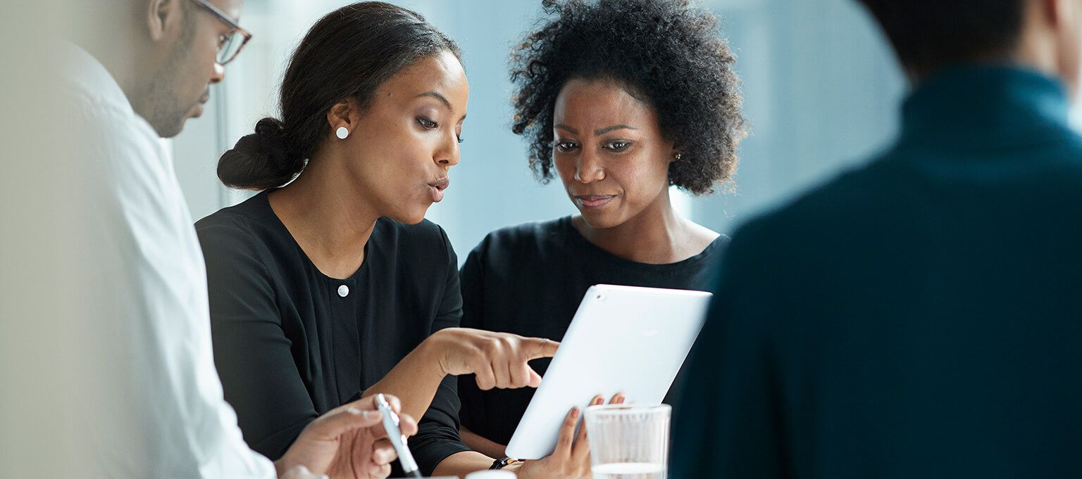 a few women looking at a tablet