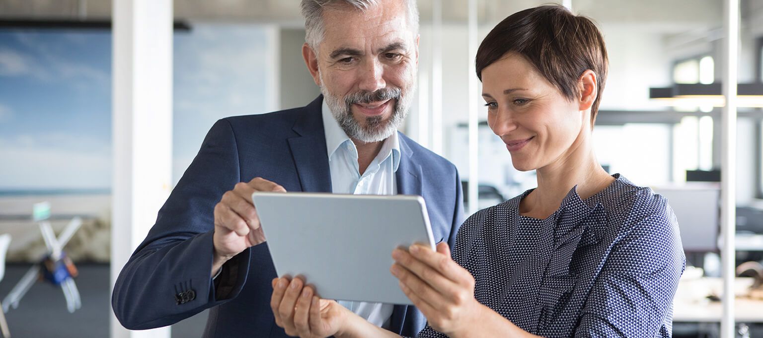 Smiling Man and woman using tablet device