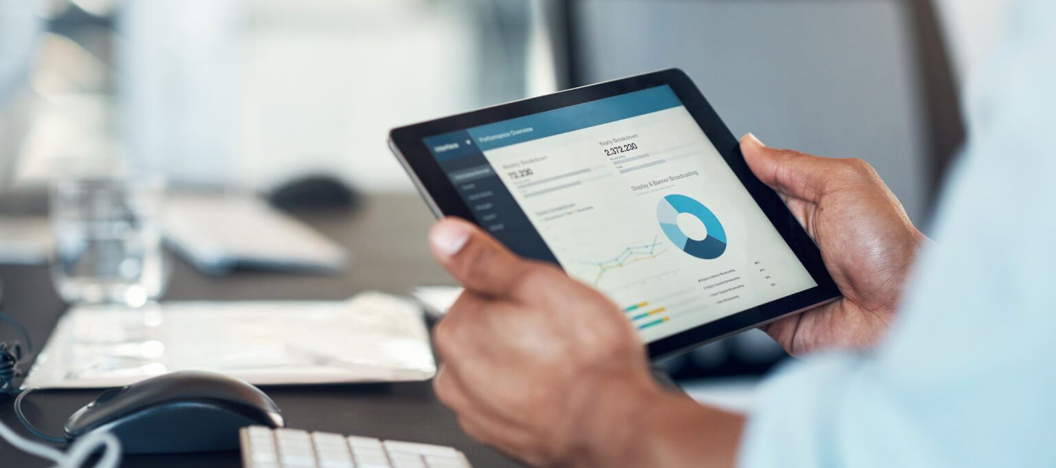 Businessman holding tablet device that is displaying financial graph