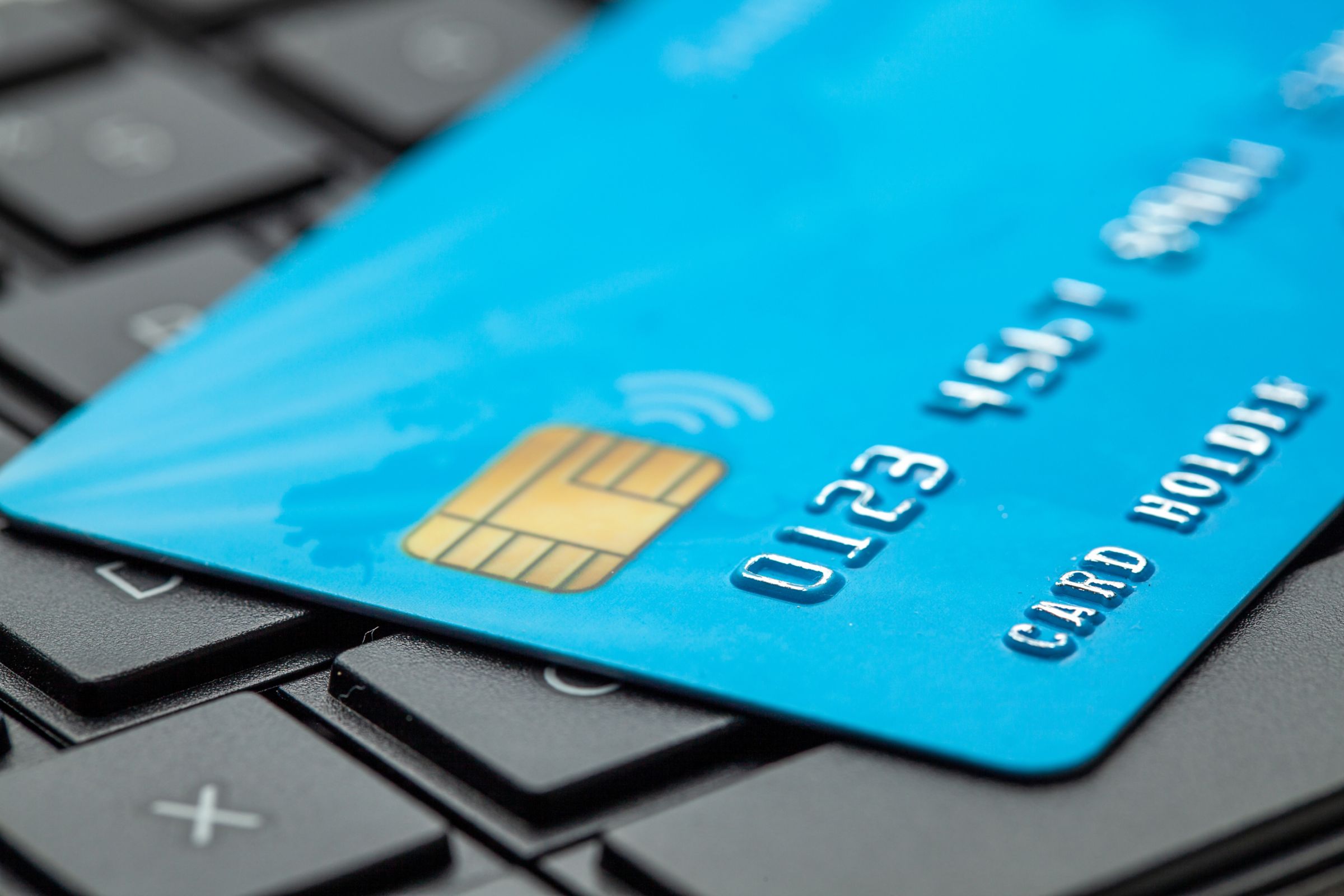 Man holding credit card with laptop in lap