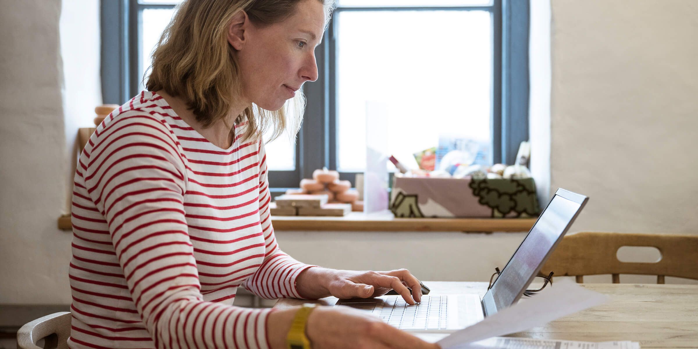 woman at table typing on laptop