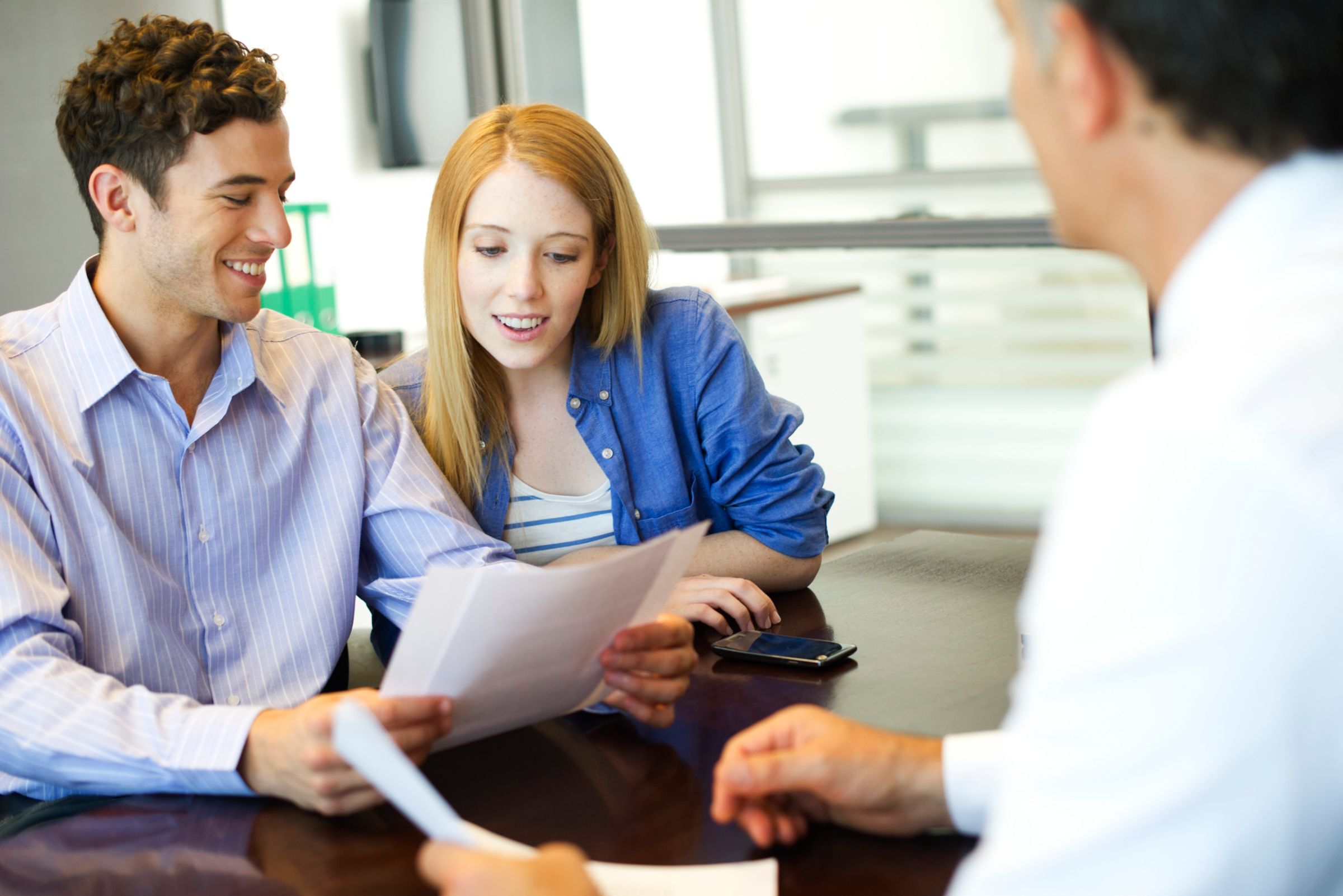 two people looking at paperwork at a bank