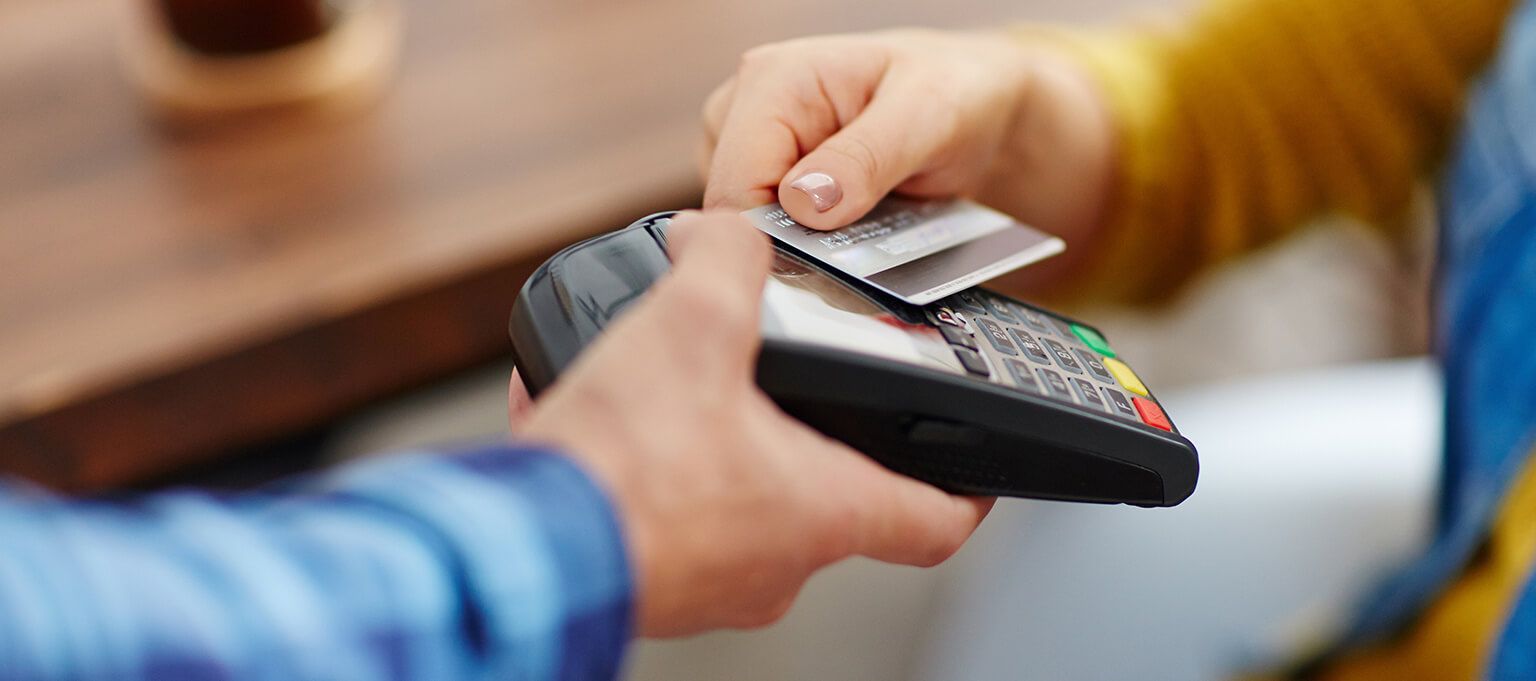 a person is tapping and paying a bill using an electronic card