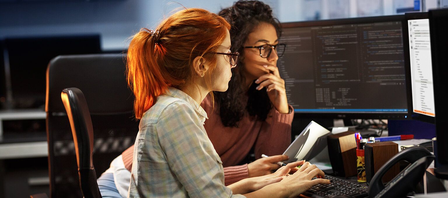 a group of women looking at a computer screen